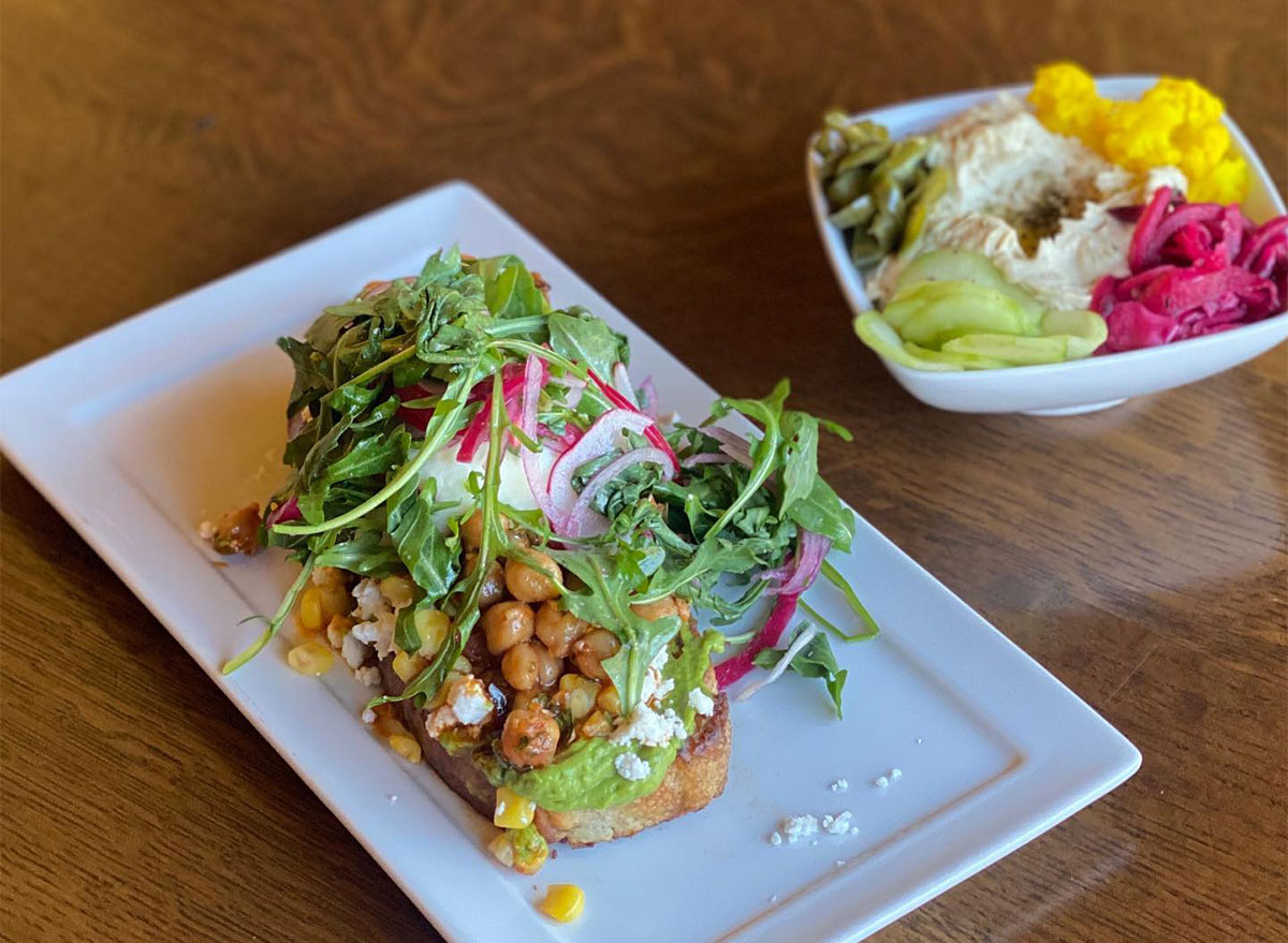 avocado toast topped with arugula and chickpeas