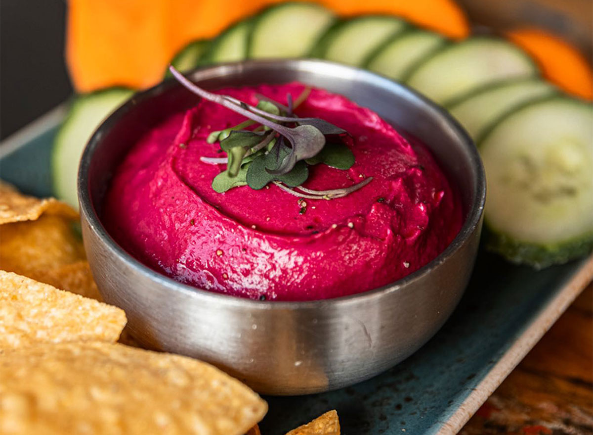 beet hummus with crackers and cucumber slices