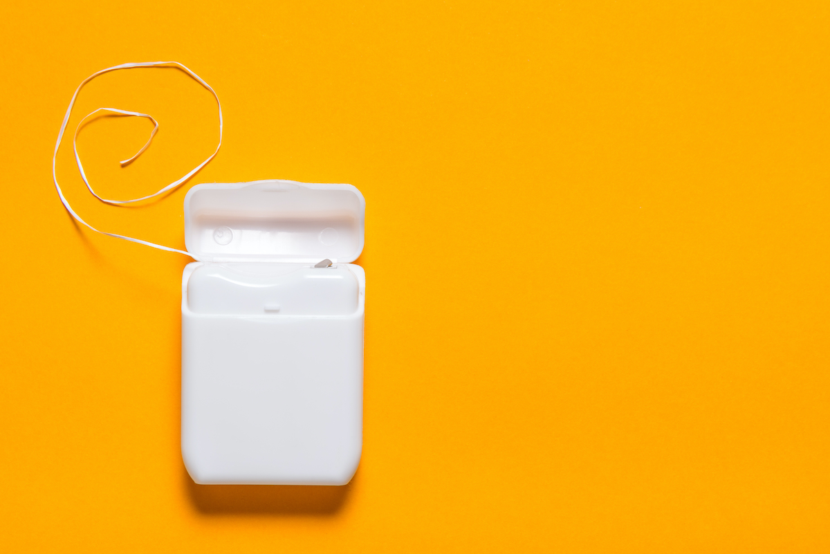 dental floss set against a yellow background