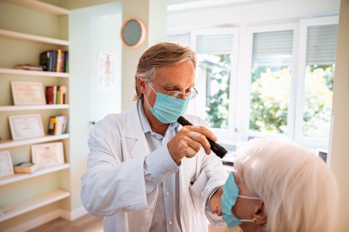 Doctor doing an eye exam on his patient.