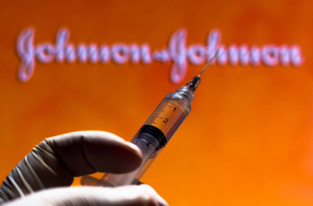 The medical syringe with Johnson and Johnson company logo displayed on a screen.