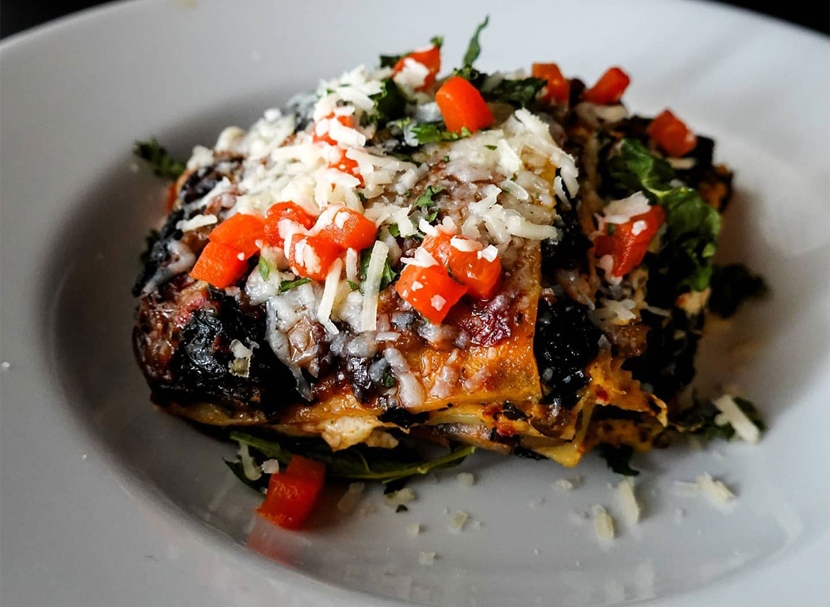 kale lasagna topped with cheese and tomatoes