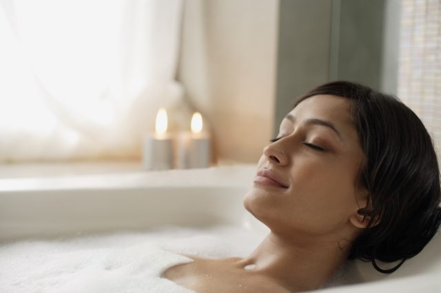 Woman reclining in bathtub