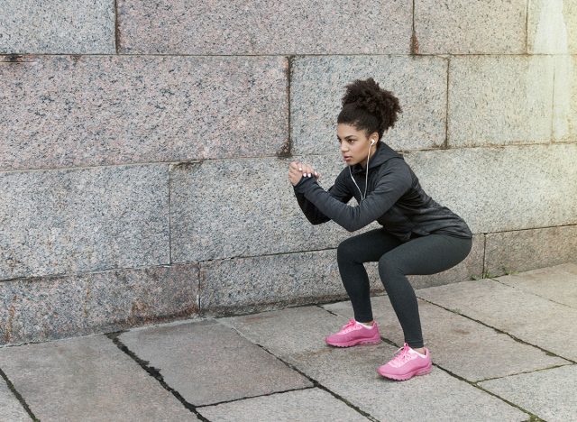 woman doing squats outside