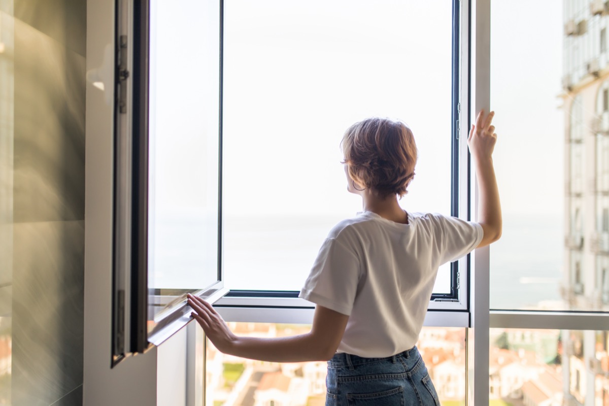 Woman open window in the morning at home