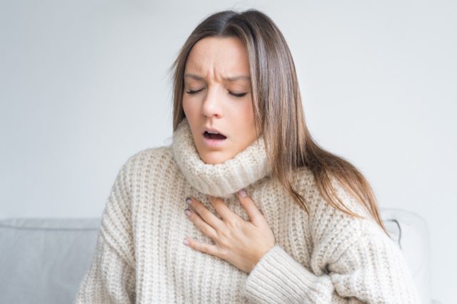 Woman having breath difficulties.