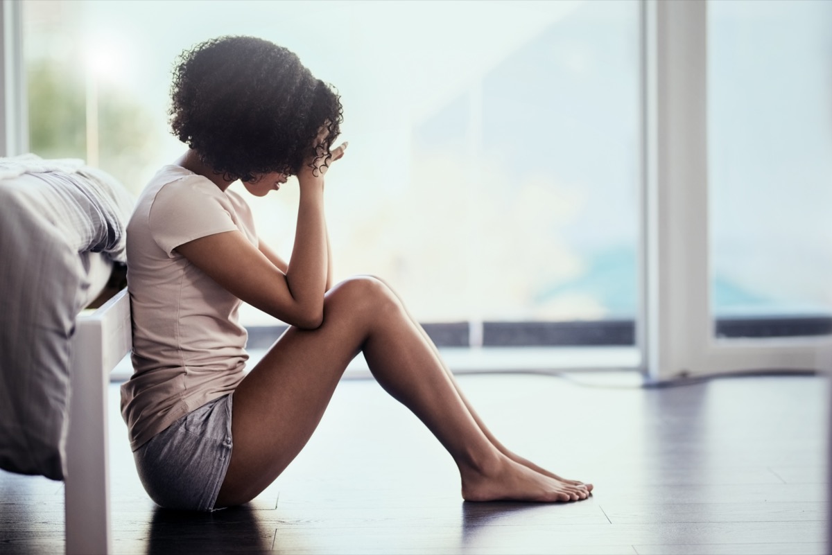 Shot of a young woman suffering from depression in her bedroom