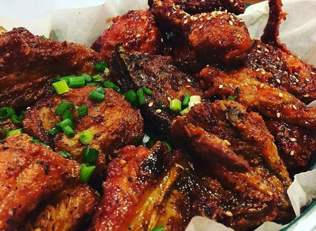 plate of chicken wings topped with scallions