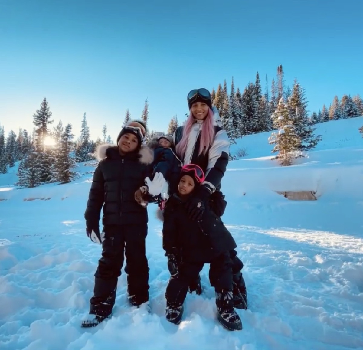 ciara and her three children skiing in black and white outfits