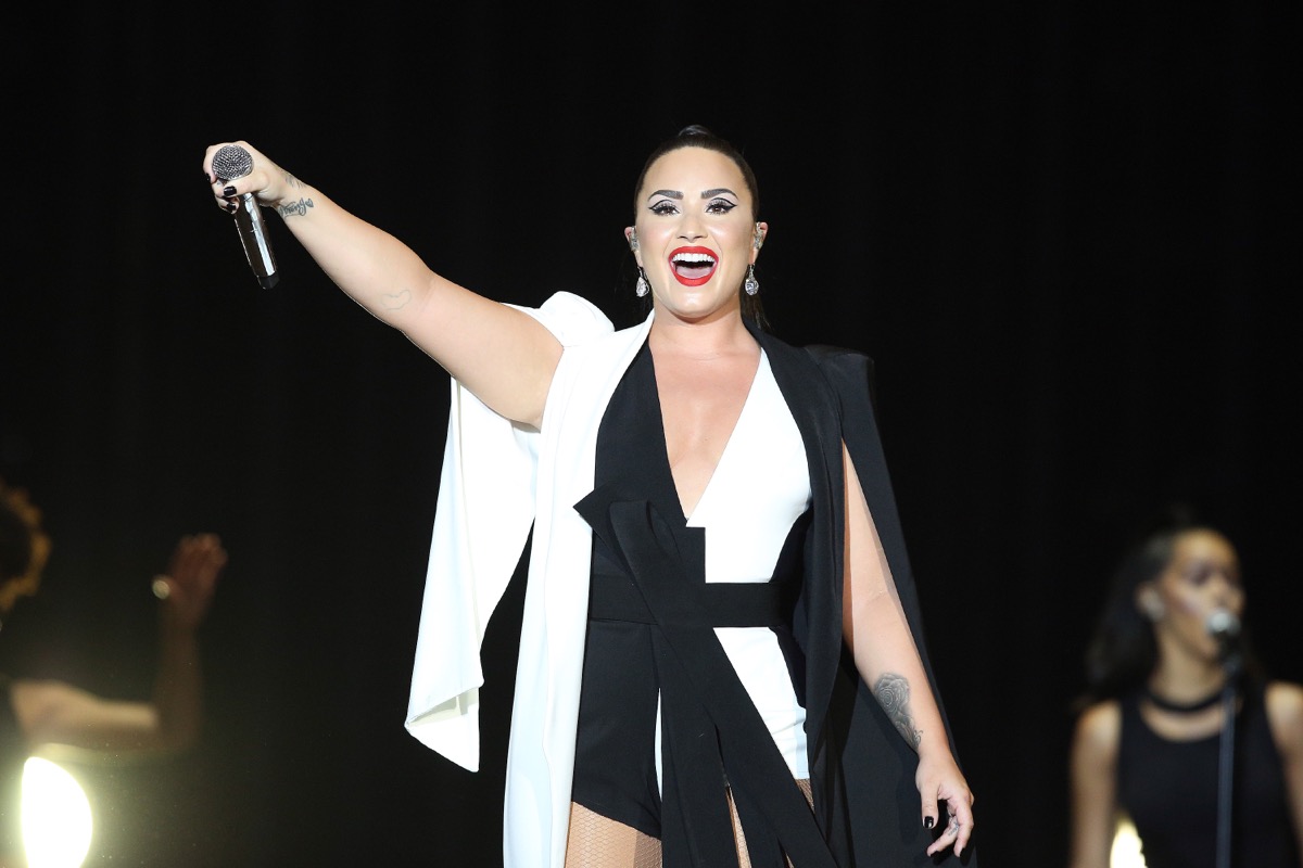 demi lovato performing on stage in black and white outfit