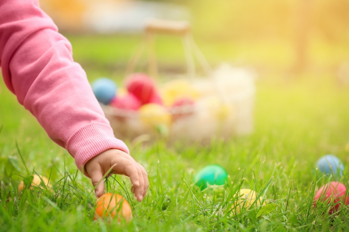 Little girl gathering colorful egg in park