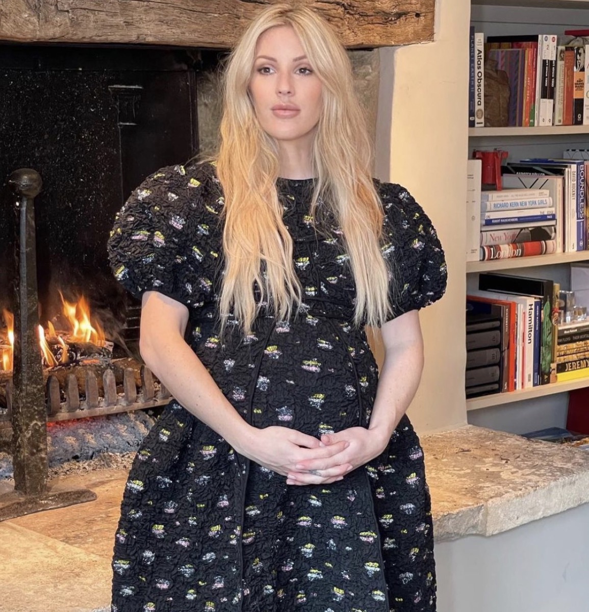 ellie goulding in a black dress clutching pregnant belly