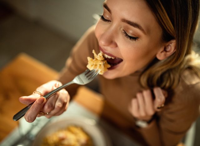 happy woman eating pasta for dinner