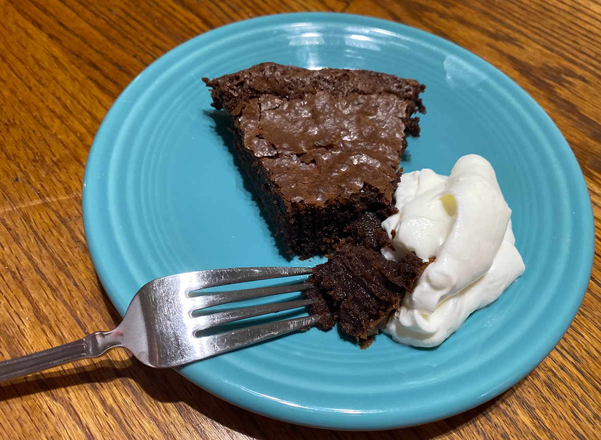 slice of chocolate cake made with ina garten's recipe with whipped cream