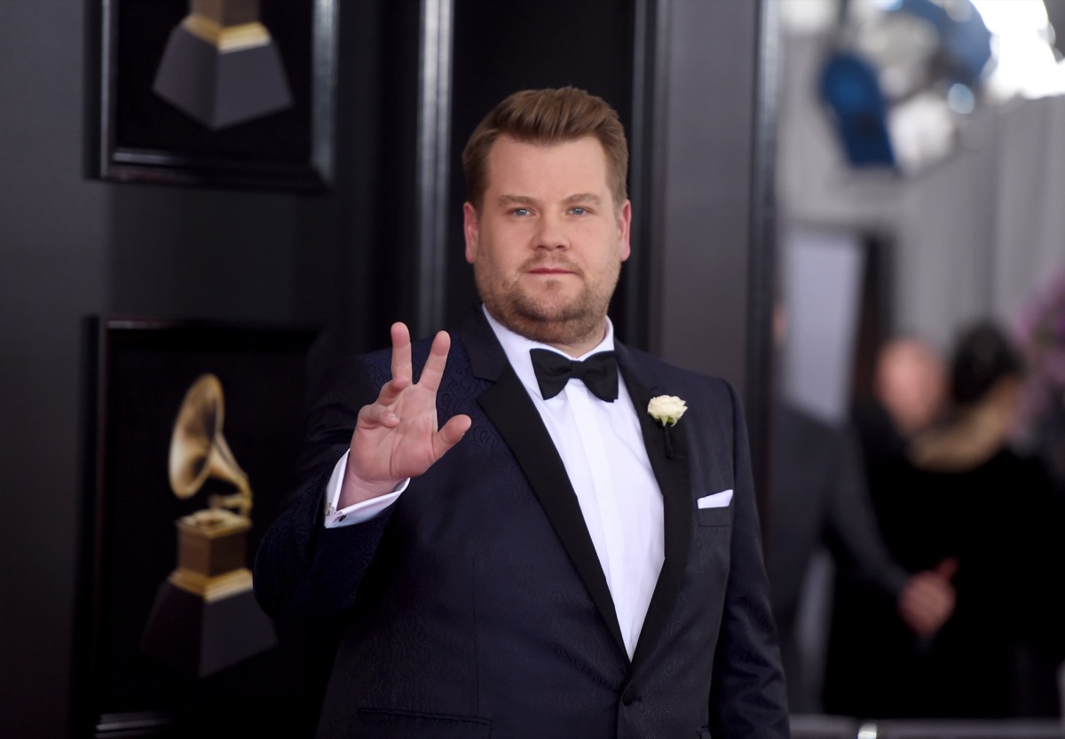 james corden in blue or black suit waving on red carpet