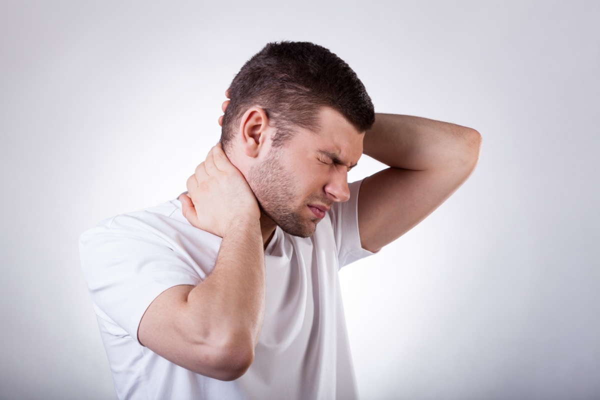 man suffering from neck pain