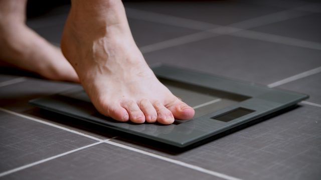 man stepping onto digital scale