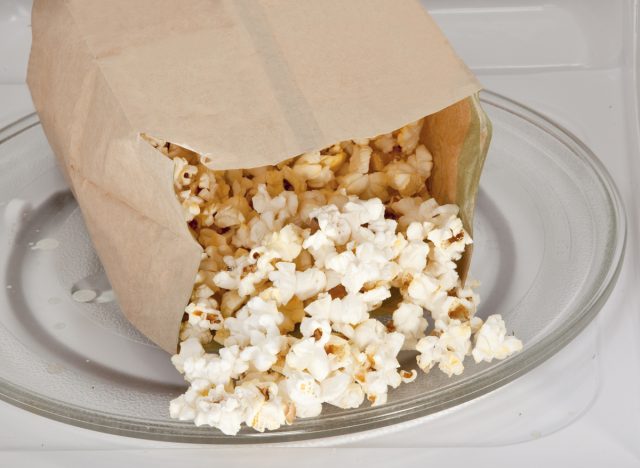 Here are 8 foods that cause belly fat due to inflammation - popcorn bag in microwave, concept of inflammatory foods that cause belly fat
