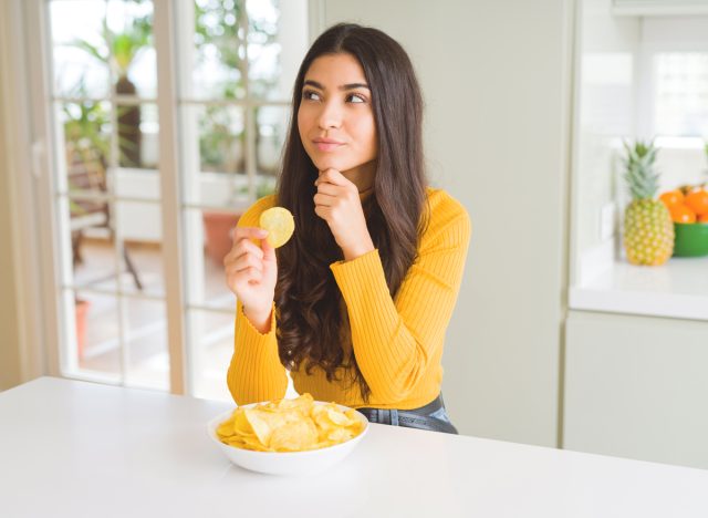 woman thinking about eating a potato chip and practicing mindful eating