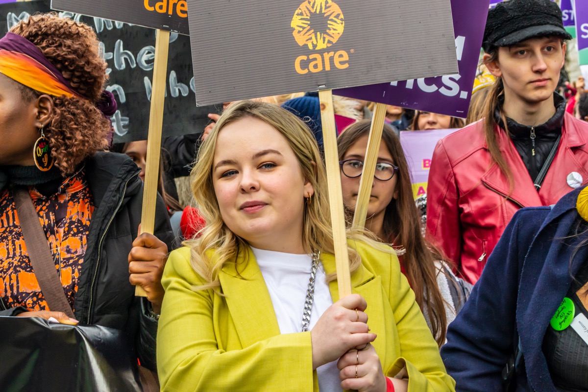 nicola coughlan in yellow jacket holding sign during women's march