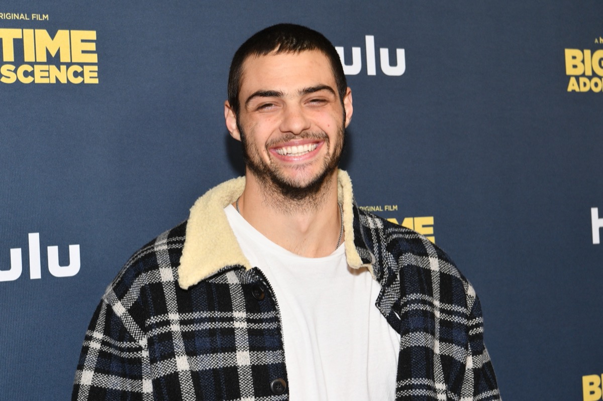 noah centineo in white t-shirt and black plaid sherpa jacket on red carpet
