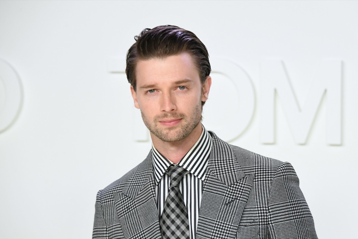 patrick schwarzenegger on runway in gray suit and striped shirt