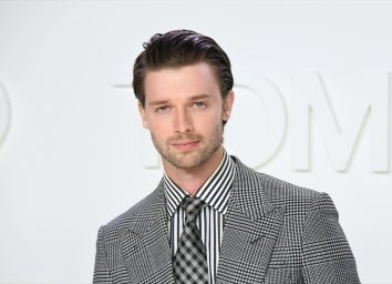 patrick schwarzenegger on runway in gray suit and striped shirt