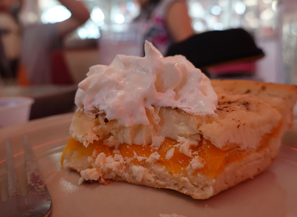 slice of peach pie topped with whipped cream