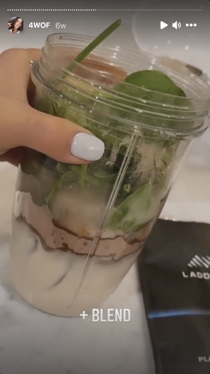 shay mitchell holding a smoothie in a blender cup
