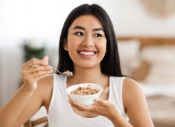 woman eating oatmeal happy