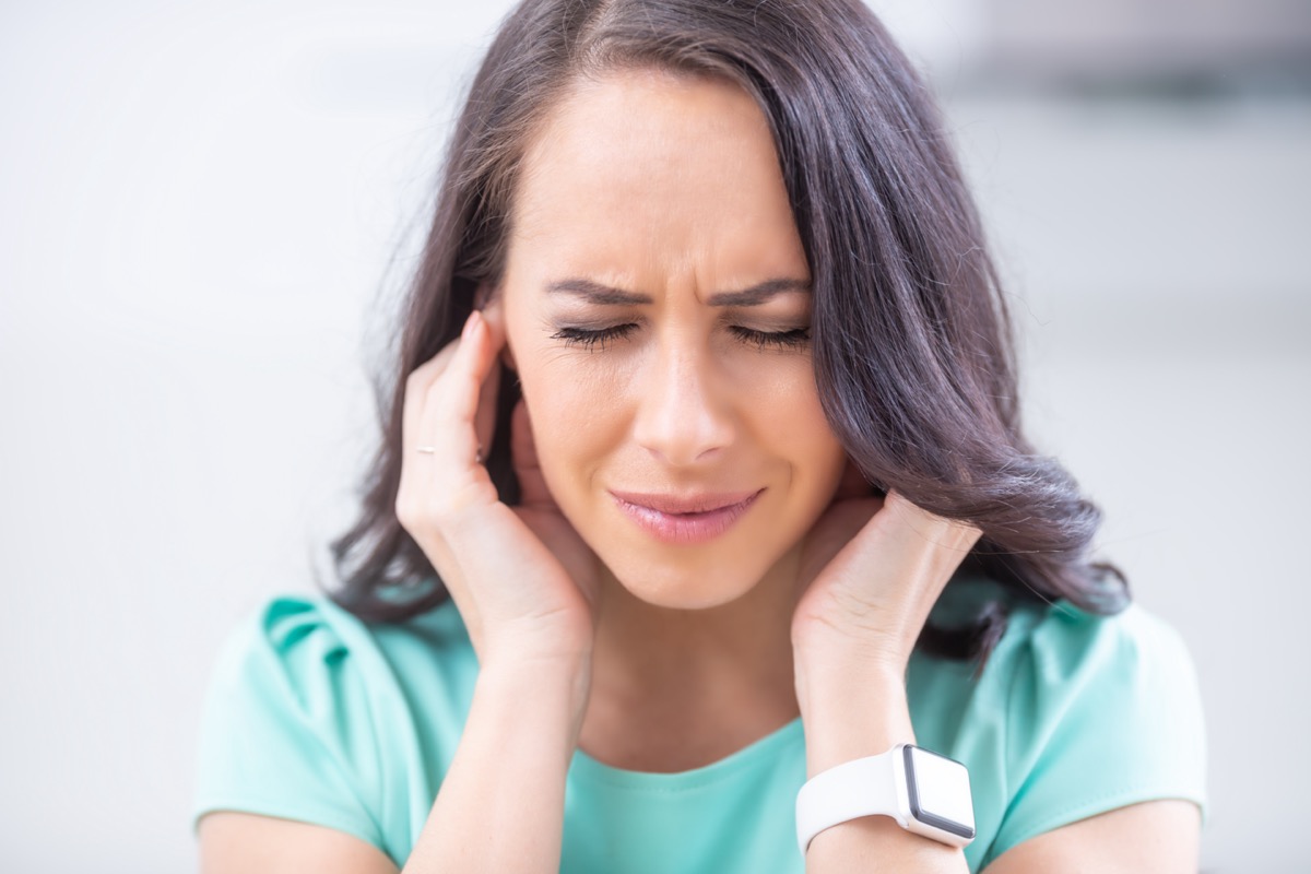 Young woman have headache migraine stress or tinnitus