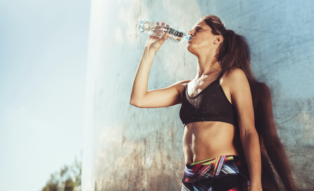 woman taking a water break during workout