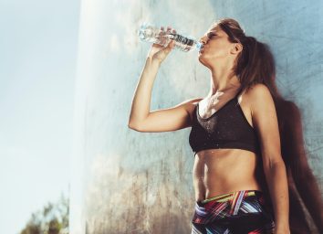 woman taking a water break during workout