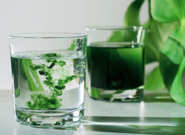 green chlorophyll water drops mixing in glass of water