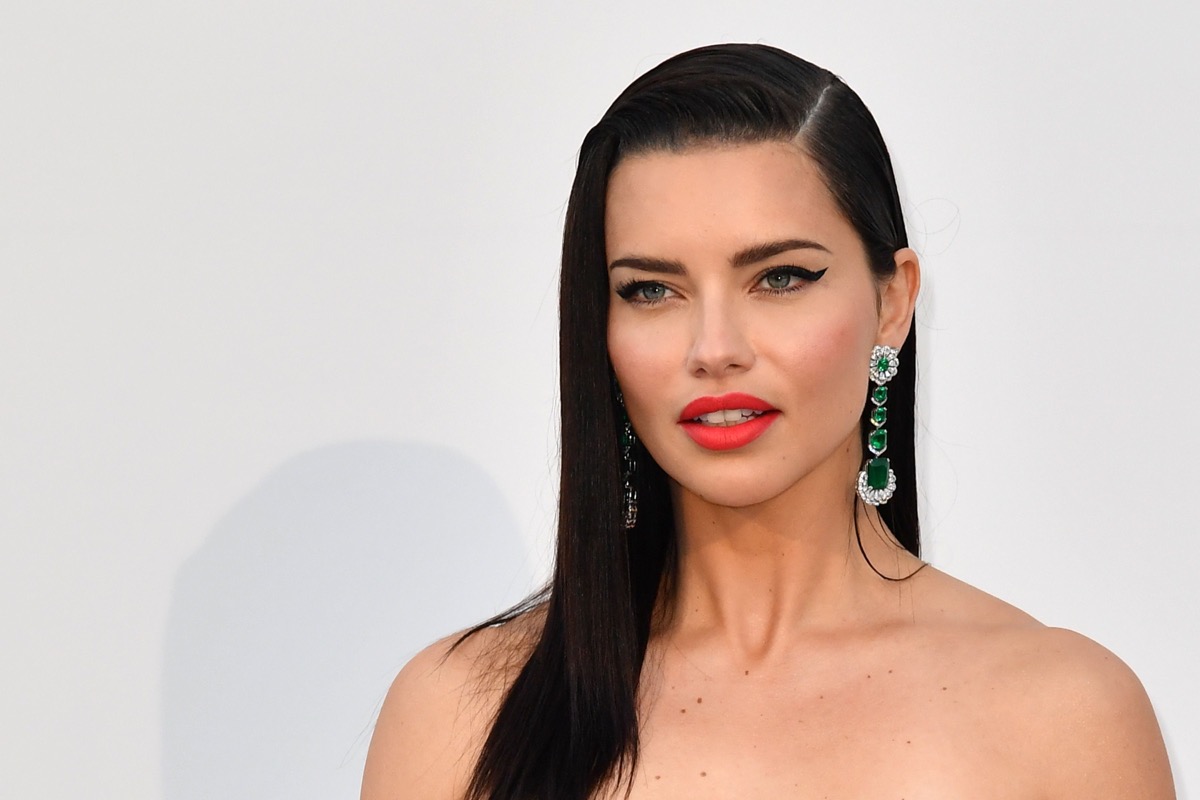 adriana lima on red carpet wearing red lipstick and black eyeliner