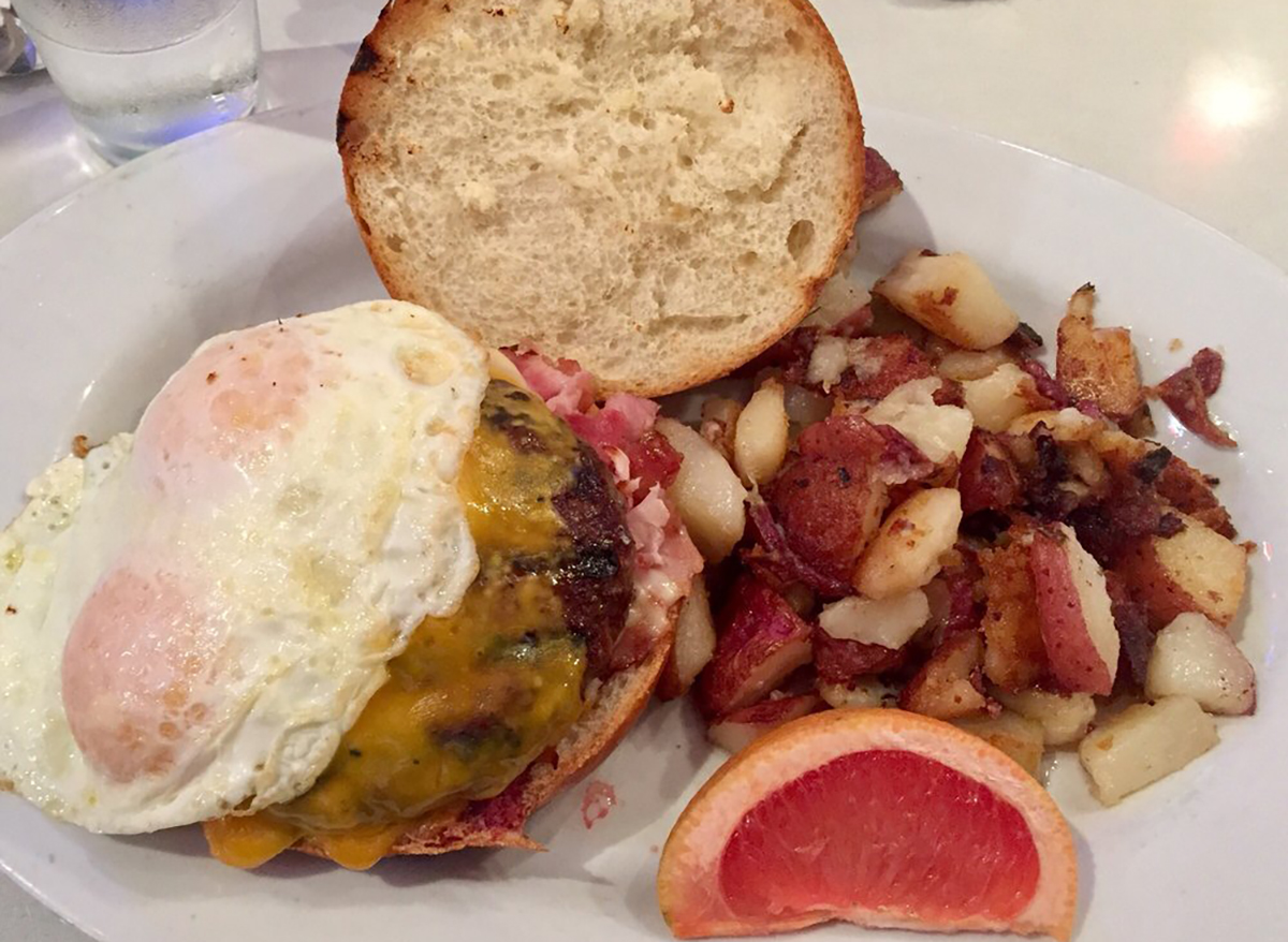 burger with home fries topped with fried egg