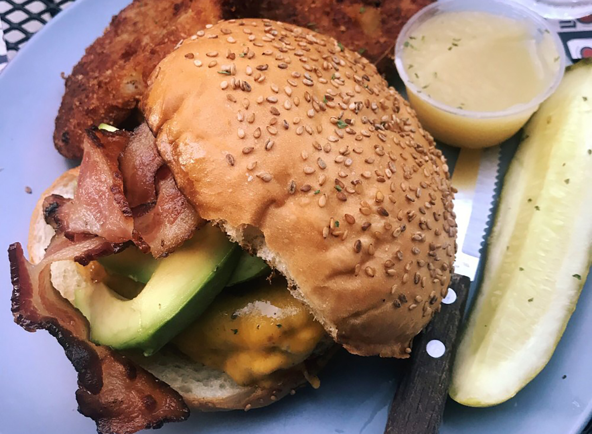 blackened chicken sandwich with avocado and pickle spear