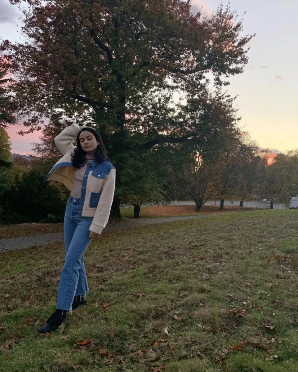 camila mendes posing in jeans and jacket outdoors