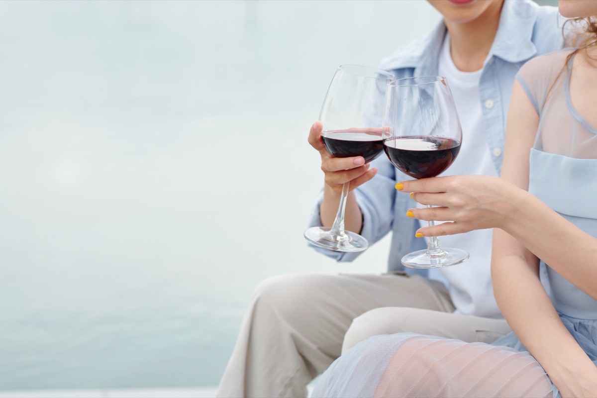 couple toasting outdoors with glasses of red wine