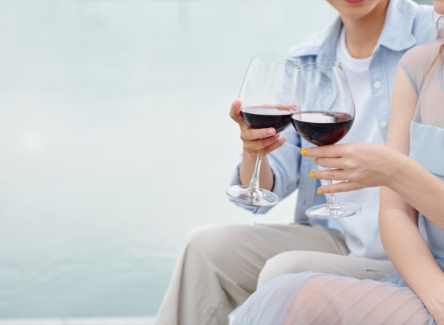 couple toasting outdoors with glasses of red wine