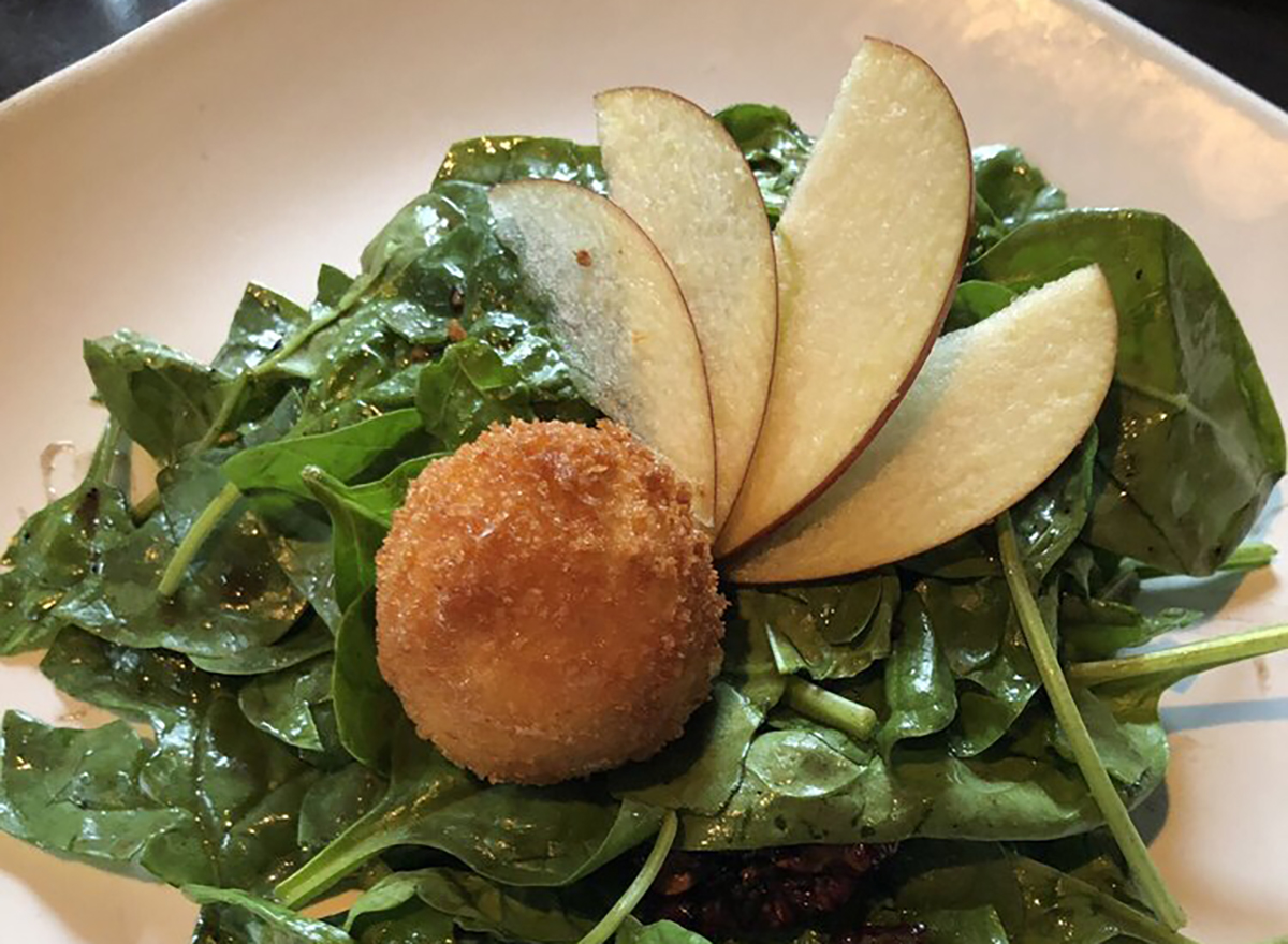 salad topped with apple slices and fried brie