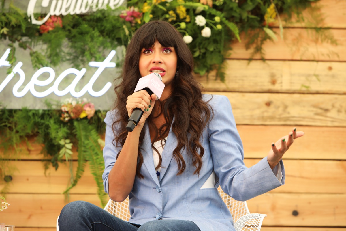 jameela jamil holding a microphone in a blue blazer