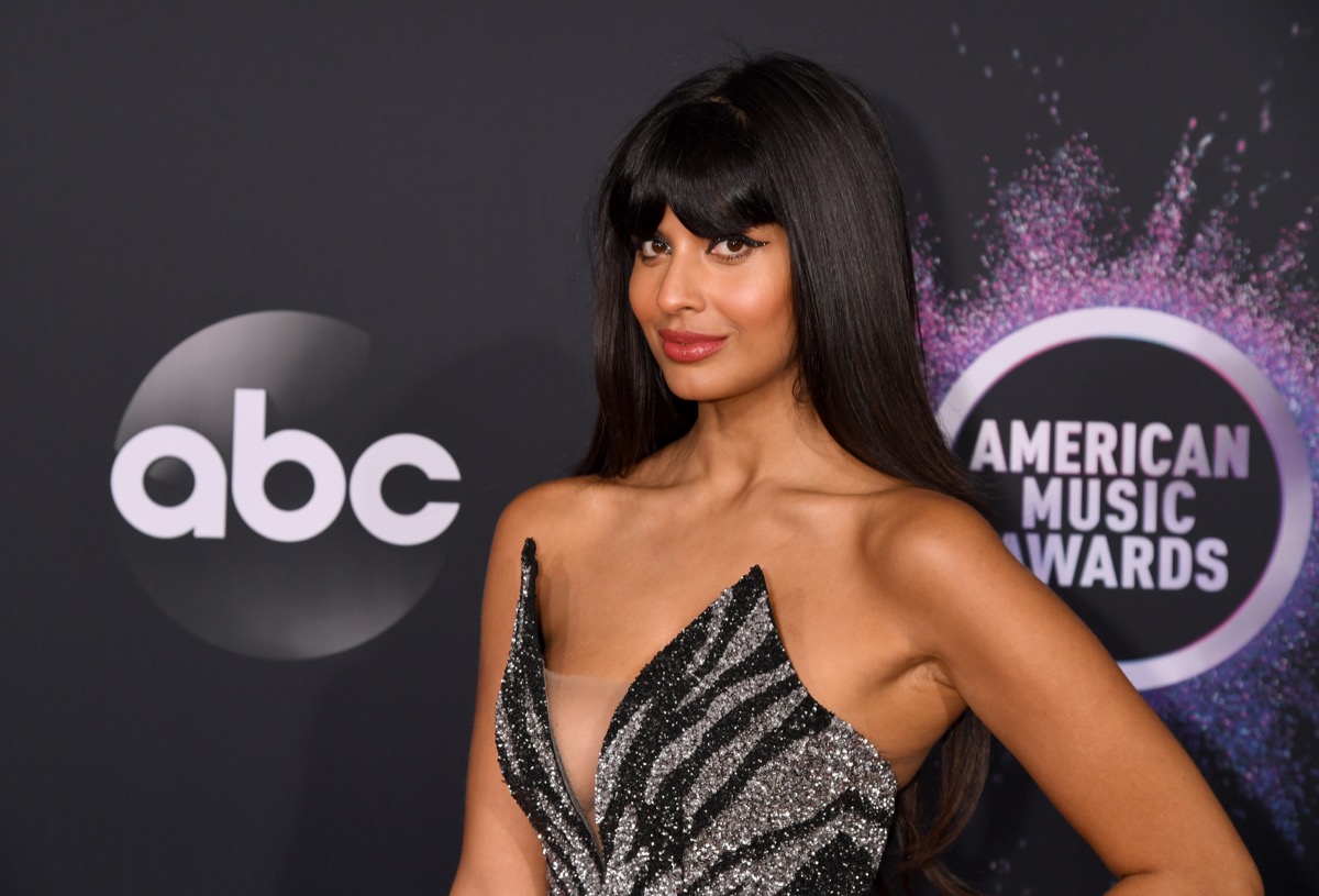 jameela jamil on red carpet in black and gray dress