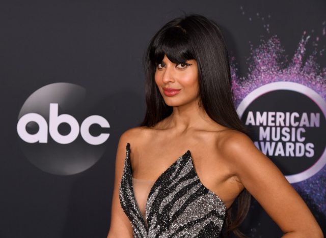jameela jamil on red carpet in black and gray dress