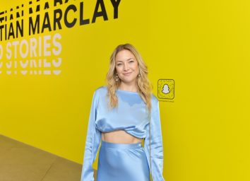 kate hudson in two-piece satin outfit in front of yellow snapchat step-and-repeat