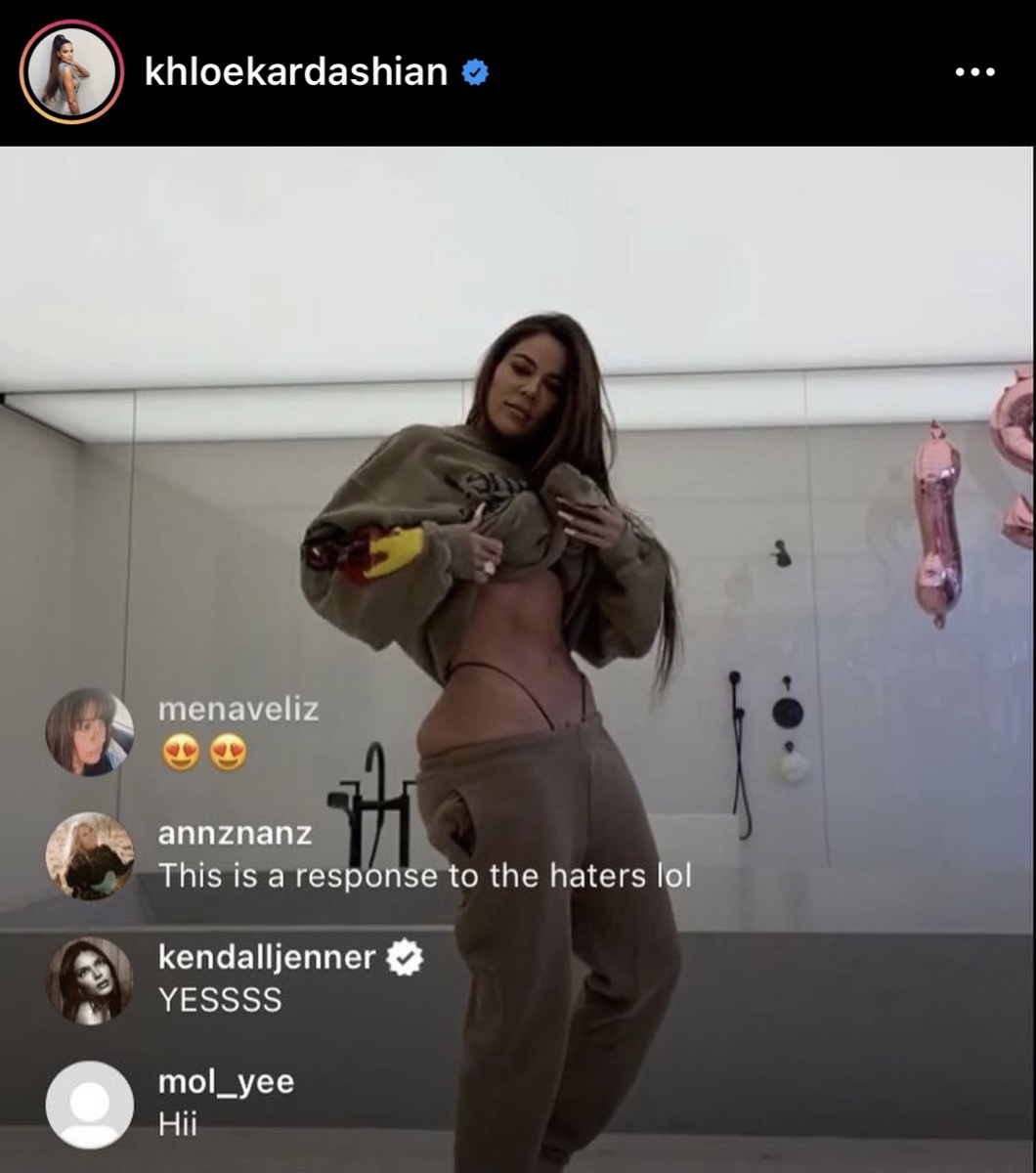 still from Instagram Live in in which Khloe Kardashian raises her sweatshirt to reveal her abs