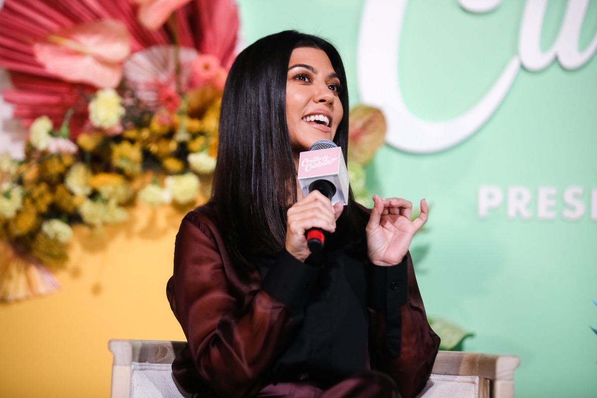 kourtney kardashian doing interview holding pink mic