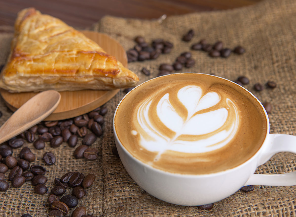 A Cup Of Cappuccino With Coffee Beans And Bread Stock Photo