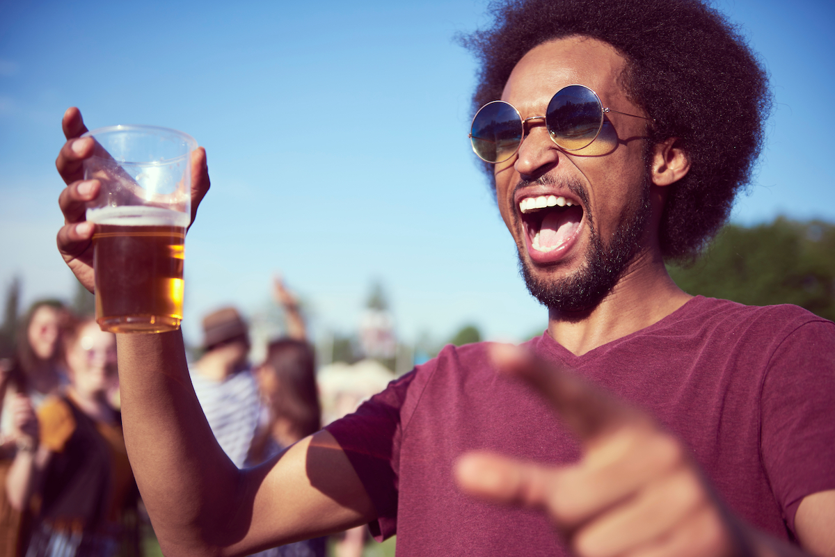 Screaming African man drinking beer at the music festival