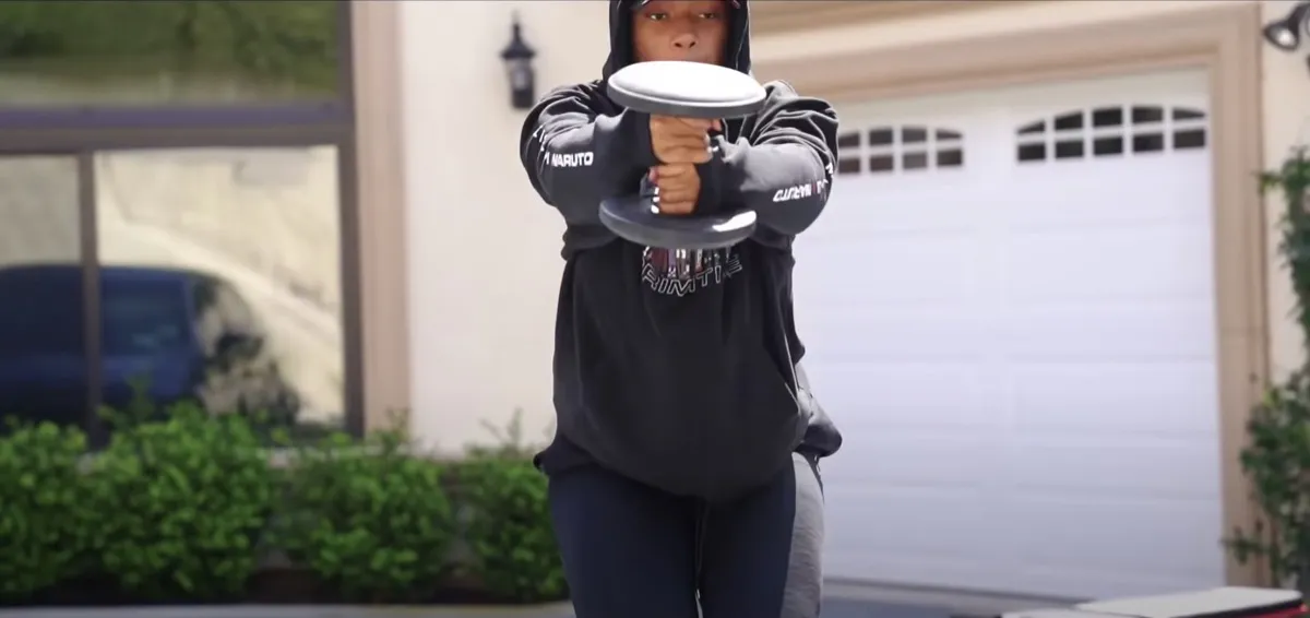 megan thee stallion holding a dumbbell outdoors